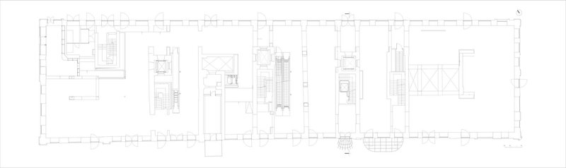 Floor plan drawing showing a long rectangular layout with central circulation and perimeter rooms