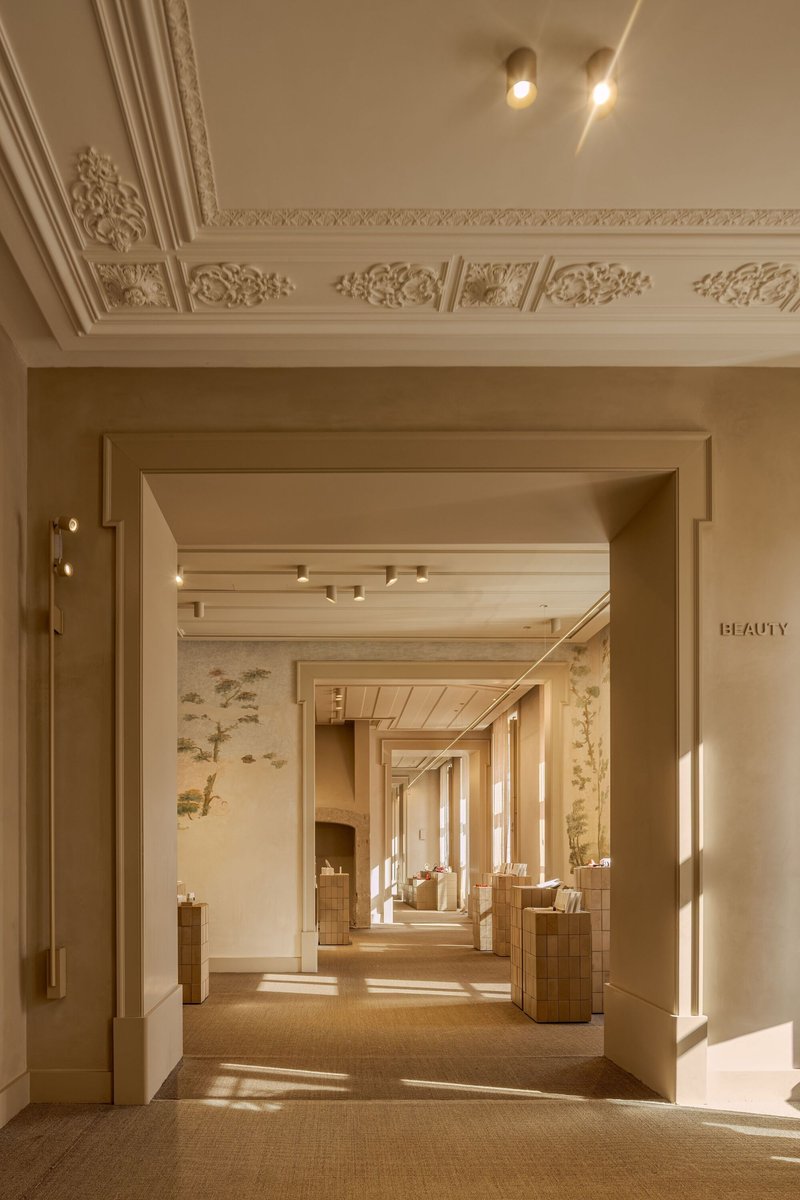 Axial view through framed doorways with ornamental plasterwork ceiling and warm afternoon light filtering through