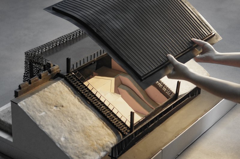 Cutaway model view showing interior courtyard spaces beneath a lifted ribbed roof section