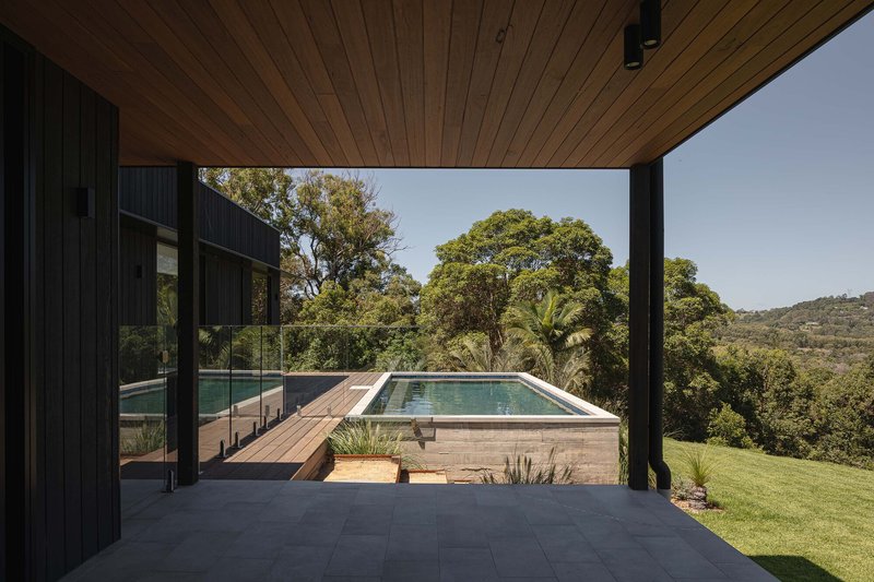 Timber soffit framing a view of the elevated pool deck and hillside beyond