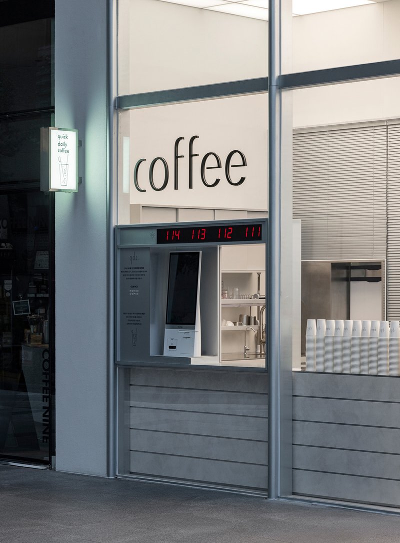 Service window with horizontal slats, digital clock display, and gray steel frame columns