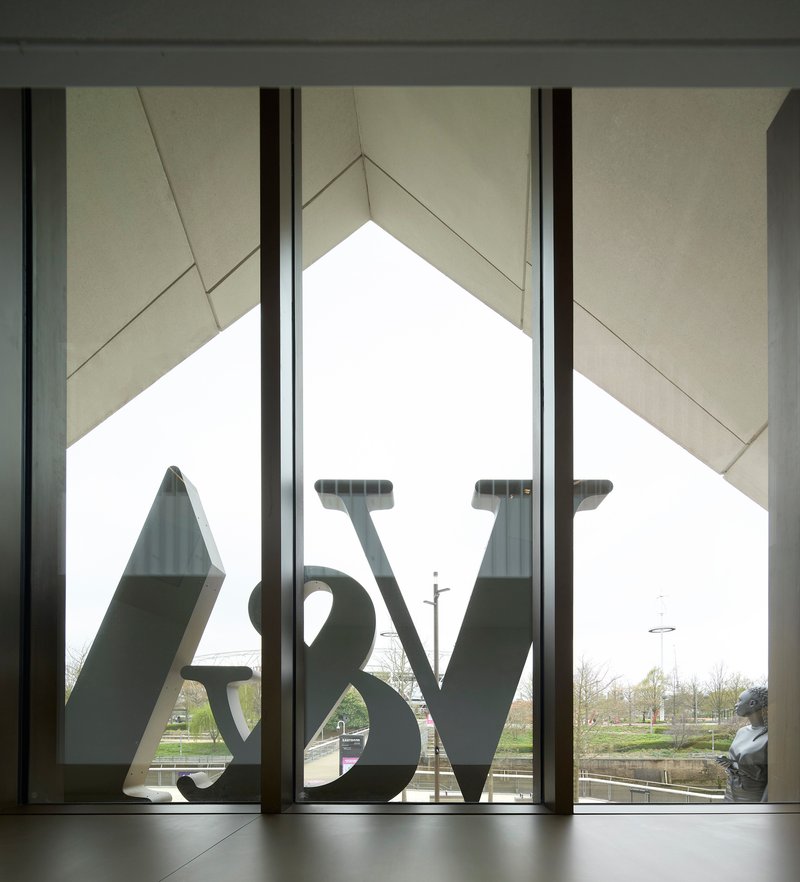 Interior view through the triangular window showing the sculpture logo silhouetted against pale sky
