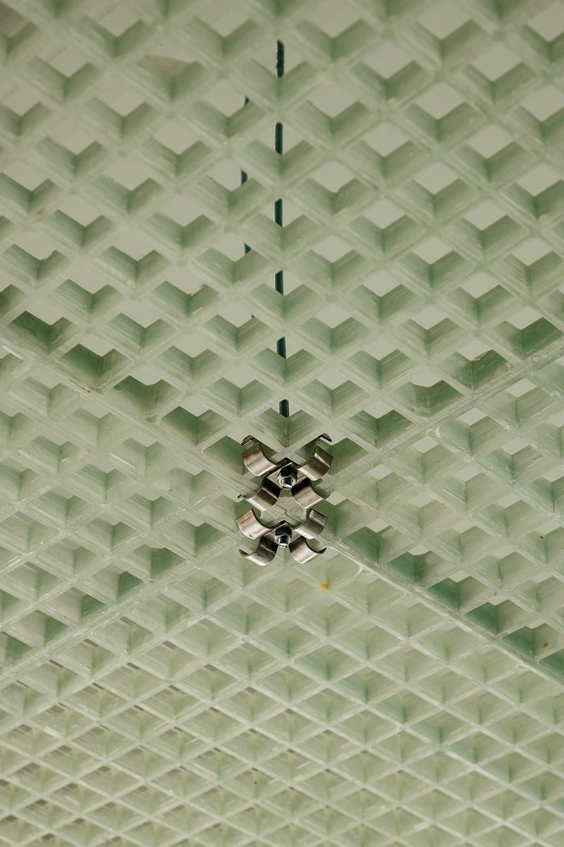 Overhead view of green chevron-patterned textile ceiling with chrome pendant lamp fittings