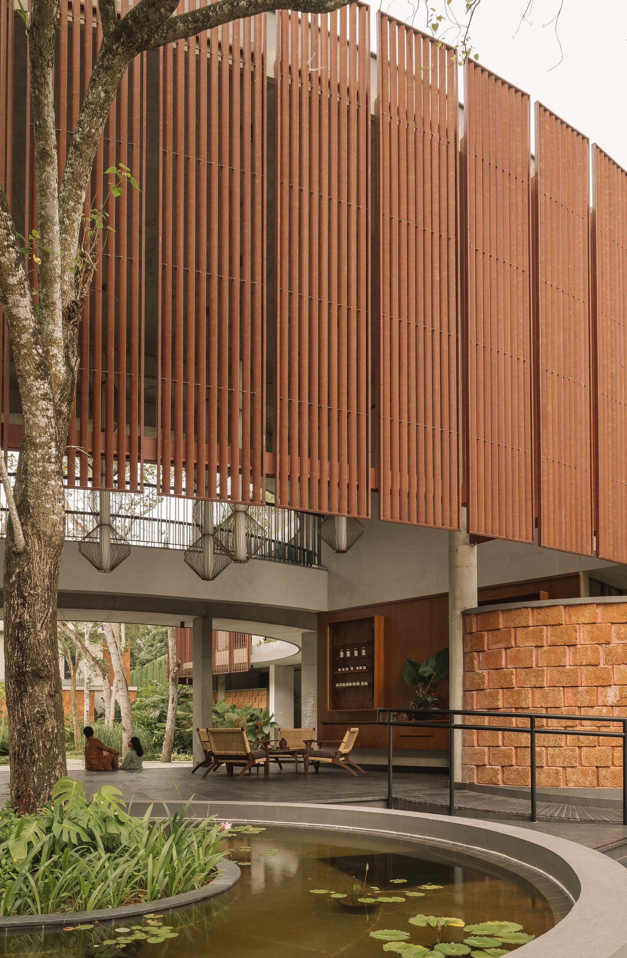 STAPATI Wraps a Kerala Ayurveda Center in Curved Timber Fins and Laterite Stone
