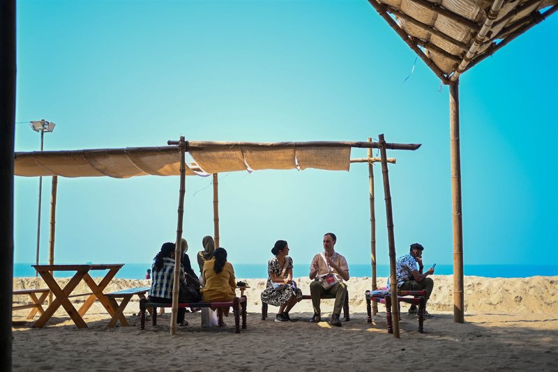 Open-air shaded seating area with canvas awning overlooking the beach and ocean