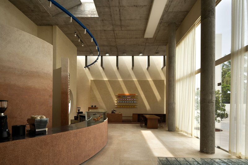 Cafe interior with sheer curtains filtering afternoon sunlight across terrazzo floor