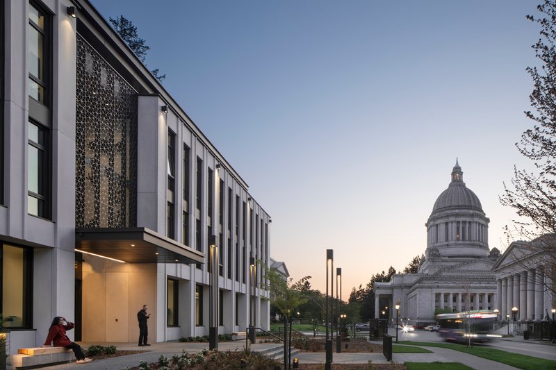 Evening view of the facade with illuminated entry and capitol dome visible under a gradient dusk sky