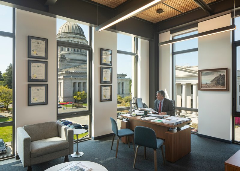 Corner office with dark steel framing and floor-to-ceiling windows overlooking a domed building