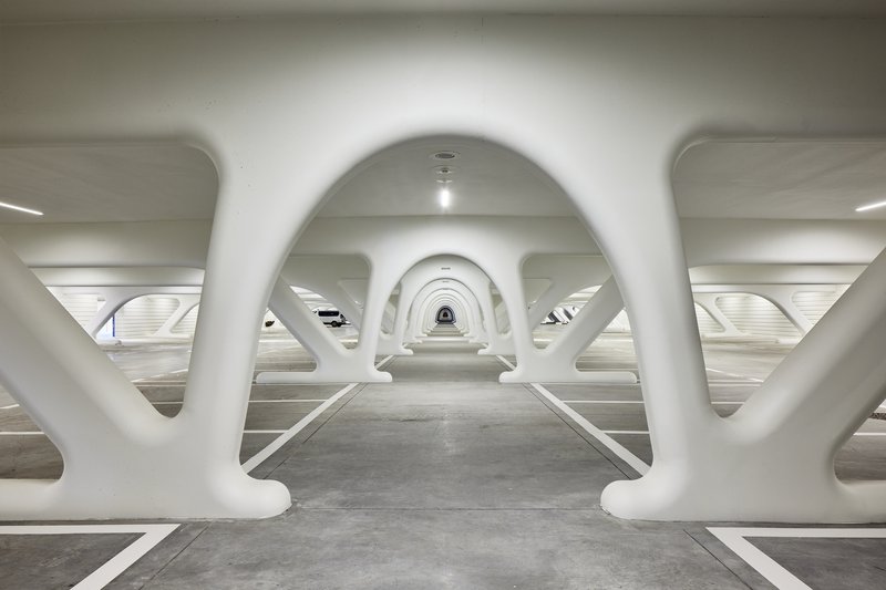 Underground pedestrian passage with repeating white arched structural frames creating rhythmic perspective