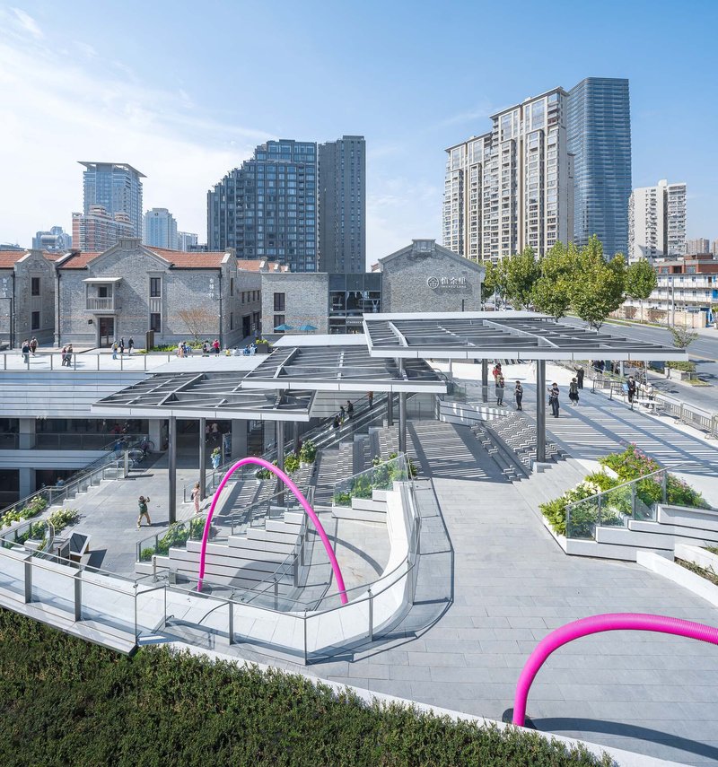 Rooftop plaza with louvered solar canopies and magenta sculptural loops over pedestrian pathways