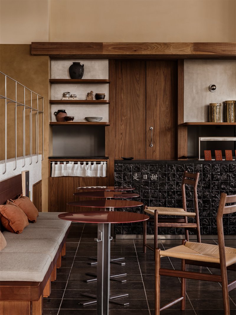 Interior dining area with walnut cabinetry, black embossed tile counter, and terrazzo flooring