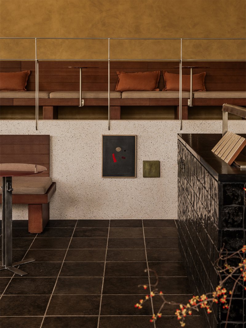 Built-in timber sleeping alcoves with brass rails and terrazzo wall below mustard panels