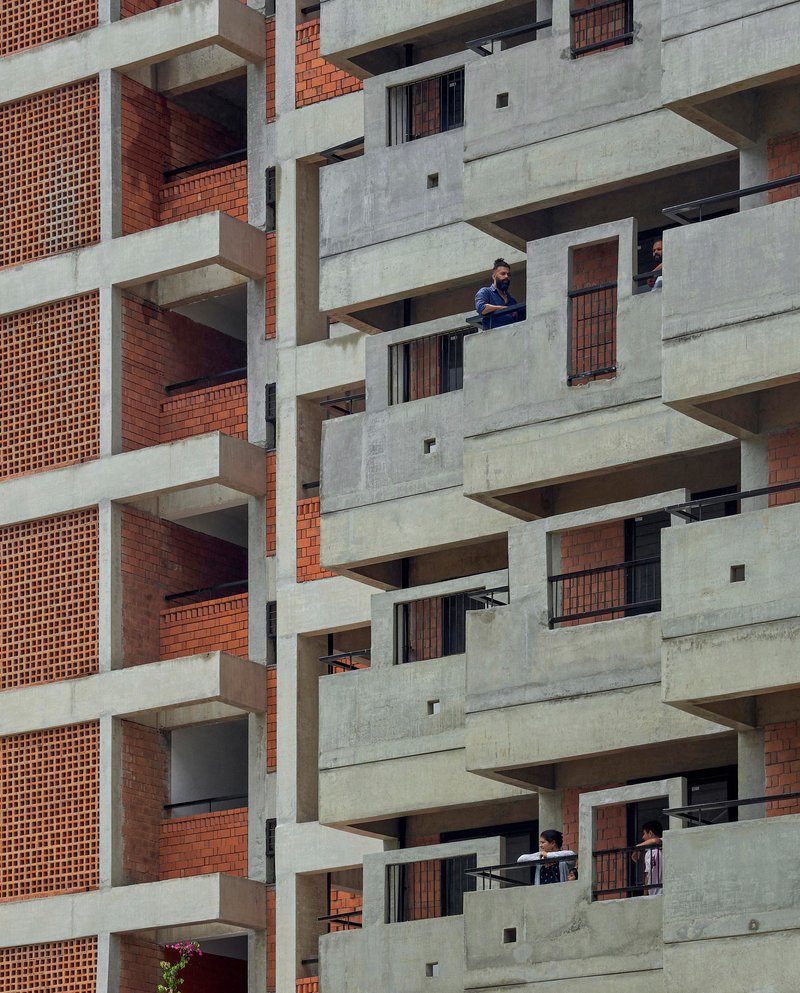 Offset concrete balconies with residents occupying the outdoor spaces at different levels