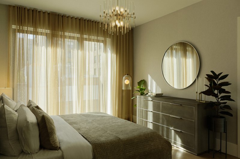 Bedroom with layered curtains filtering afternoon sunlight across the bed and dresser