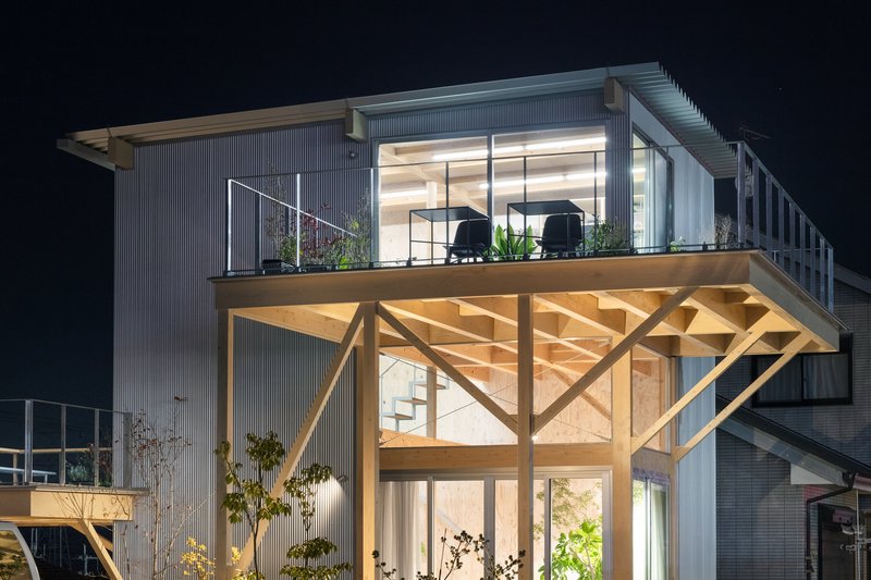 Close-up of the exposed timber truss supporting the upper deck and roof overhang at night