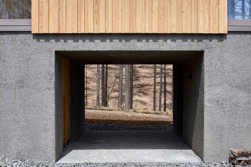 Deep window recess framing view of the forest floor through concrete walls