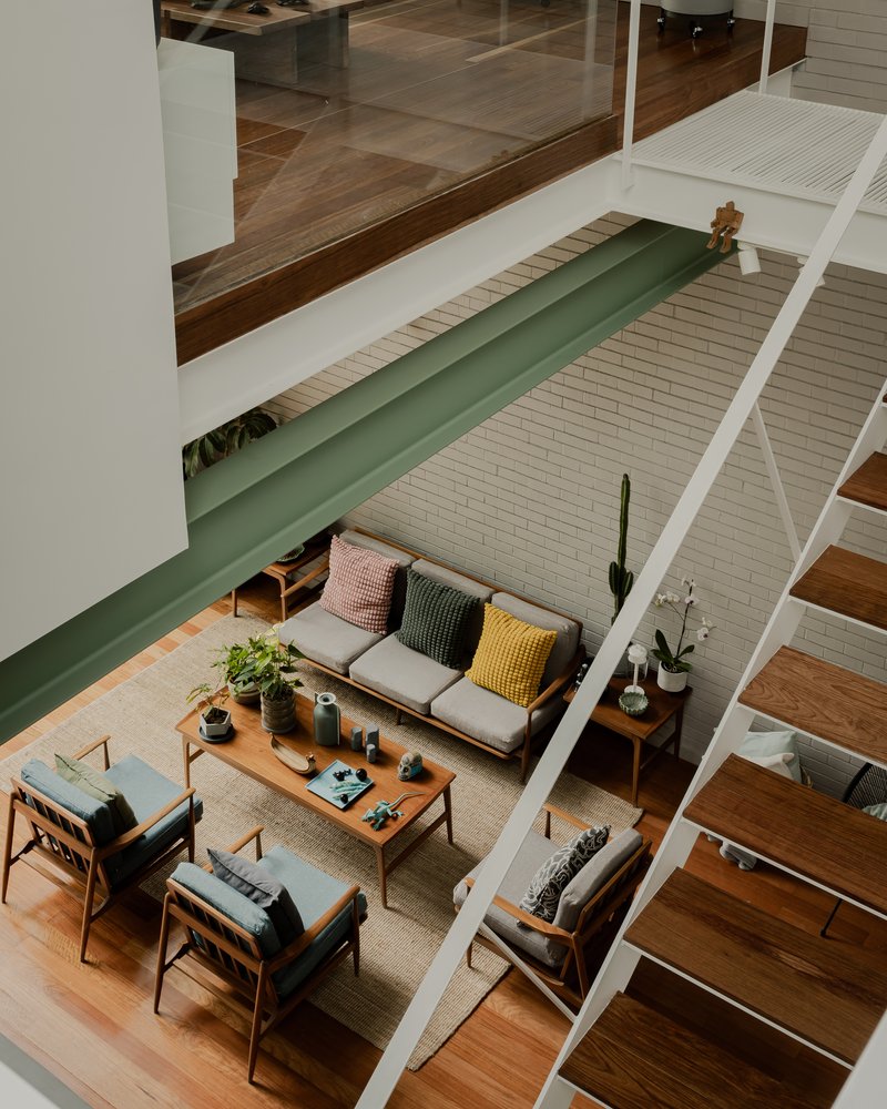 Overhead view of the living room with exposed timber beams and a green steel bridge