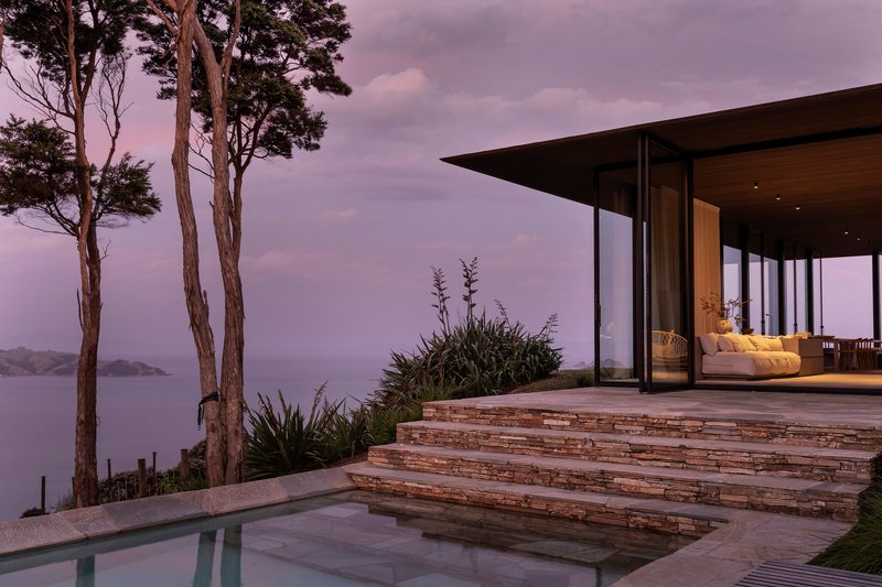 Terrace with layered stone steps and infinity pool overlooking the ocean at dusk