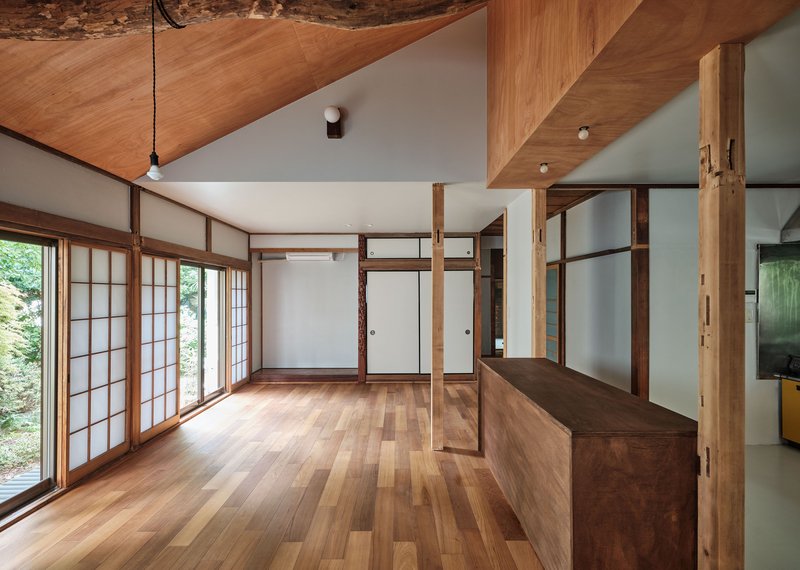 Interior with shoji screen windows, timber flooring and a raised platform with open shelving