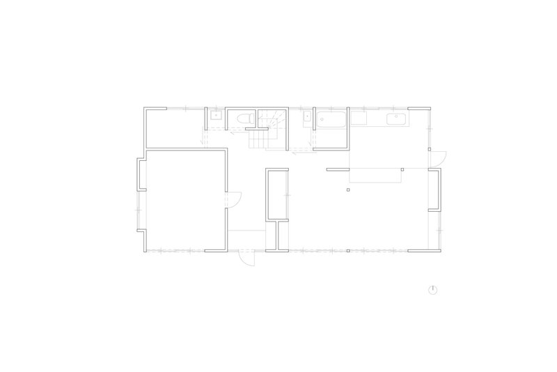 Floor plan drawing showing a rectangular layout with central stair, bathroom cluster, and open living space