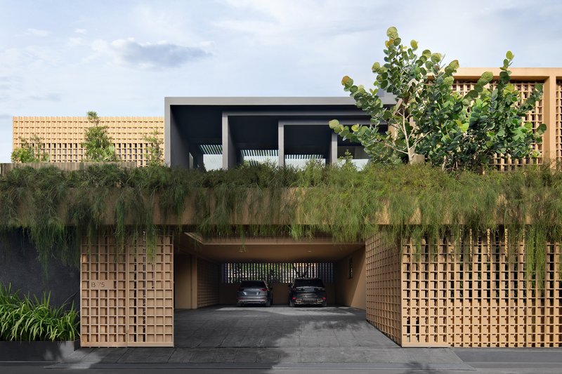 Street view of the entrance with sliding lattice gates opening to a carport beneath planted terraces