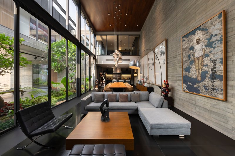 Double-height living room with floor-to-ceiling glazing overlooking an interior garden courtyard