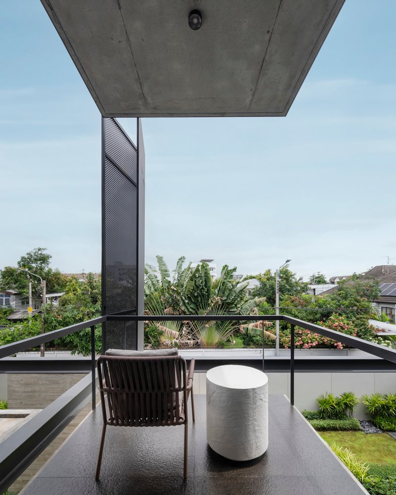 Rooftop terrace with metal railing and perforated screen column overlooking residential neighborhood
