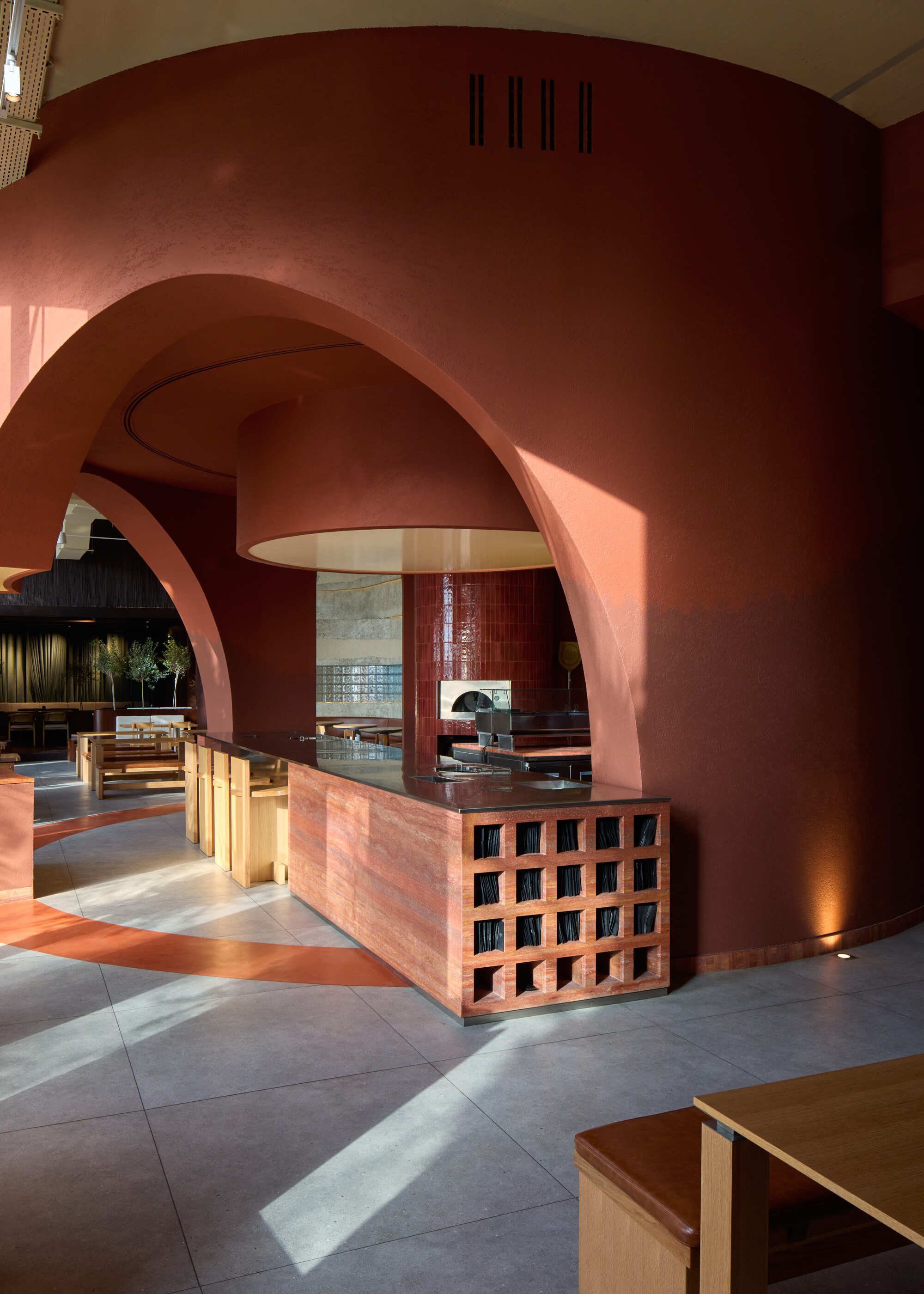 Kidz Studio Grounds a Chain Pizzeria in Abu Dhabi with Sandstone, Copper, and Botanical Geometry