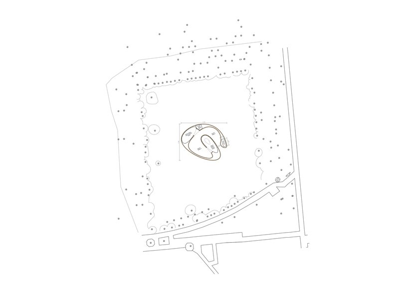 Site plan drawing showing an organic-shaped structure surrounded by landscaping and perimeter trees
