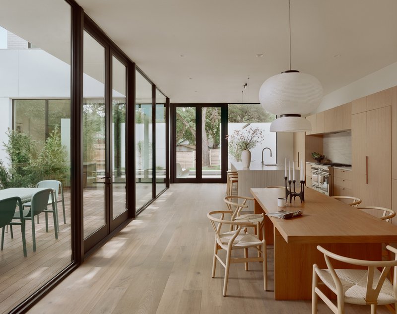 Kitchen and dining area with glazed doors opening to a planted courtyard terrace