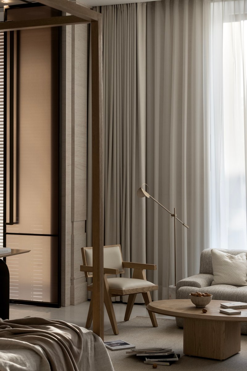 Living area with floor-to-ceiling curtains, timber chairs, and a brass articulating floor lamp
