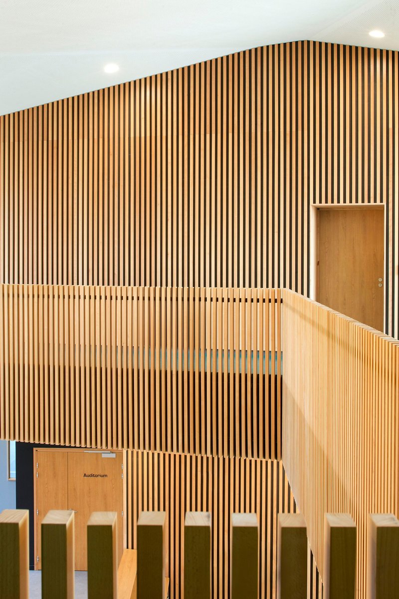 Angled view of timber slat wall showing recessed door and balustrade top rail