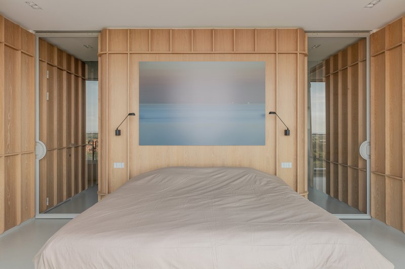 Bedroom with vertical timber paneling flanking the bed and mirrored sliding doors on each side