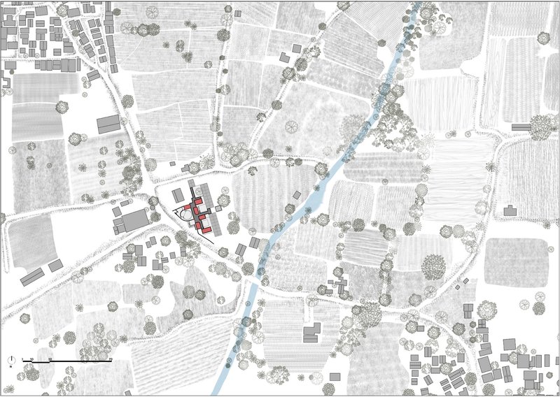 Site plan drawing showing the building footprint among agricultural plots, roads, and scattered vegetation in the landscape