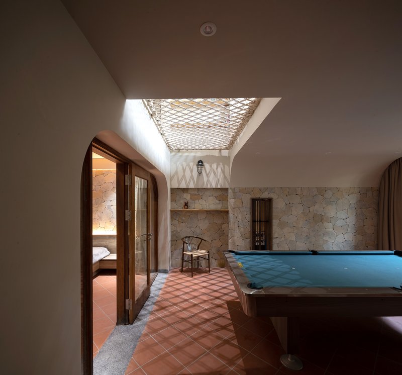 Interior corridor with terracotta tile floor and rope net skylight filtering daylight from above