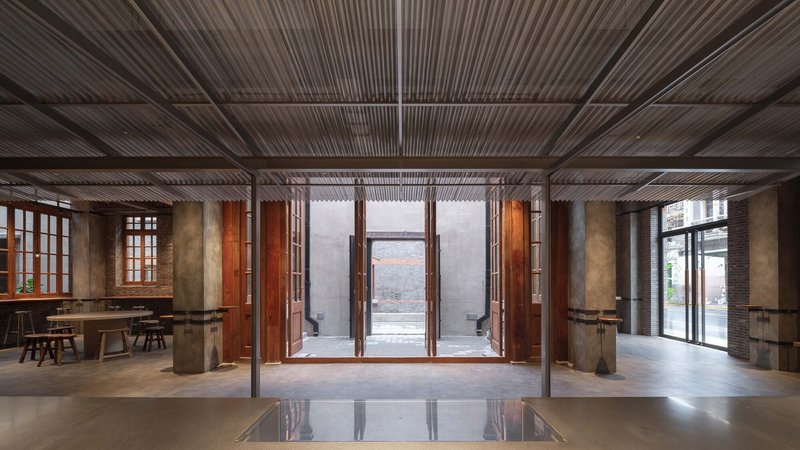 Central hall with timber-louvered ceiling looking toward large folding doors opening to exterior courtyard