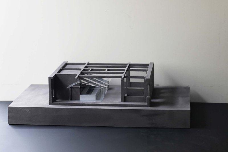 Physical model showing exposed structural frame and interior courtyard under natural light