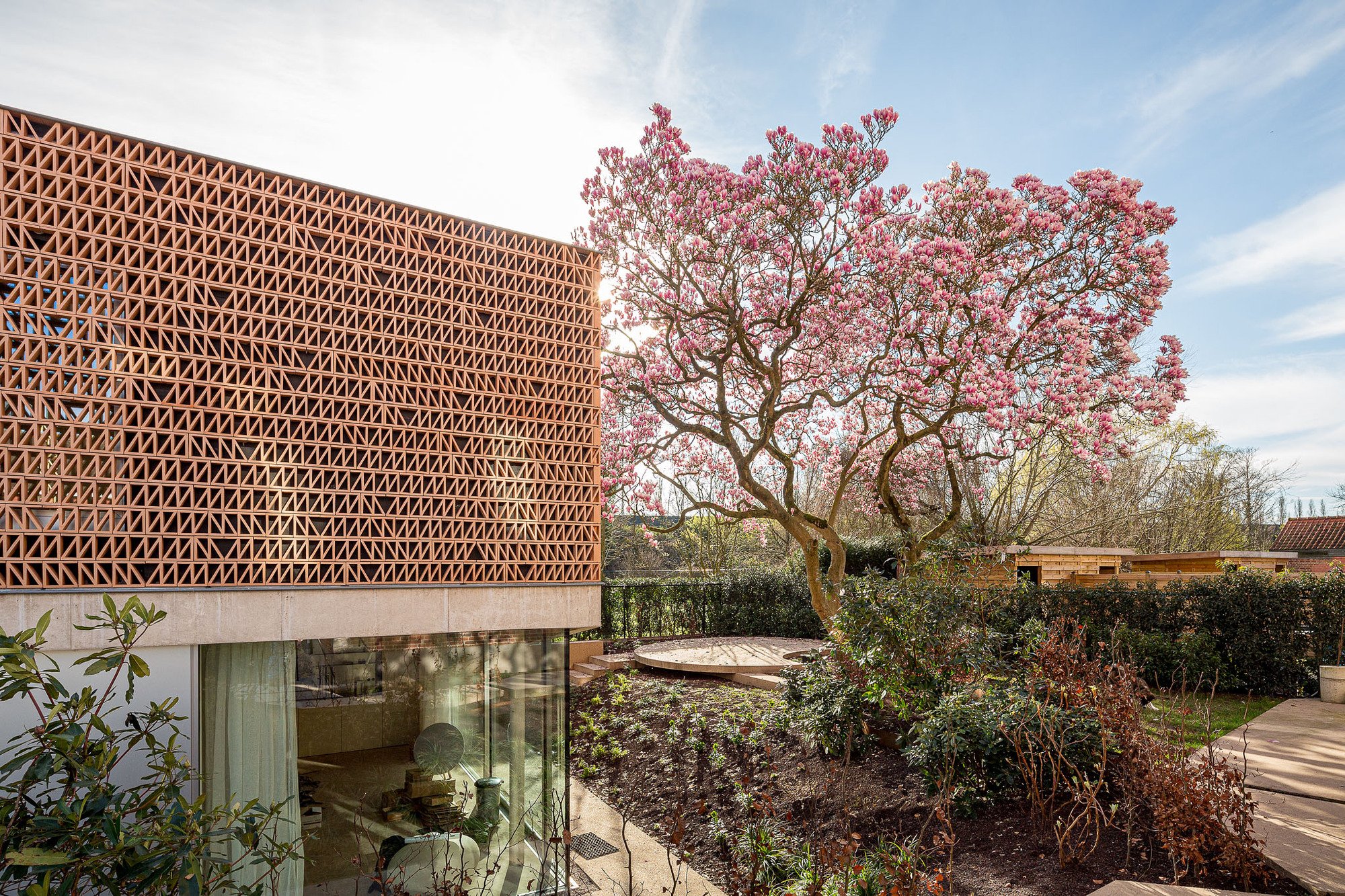 Vi.architectuur.atelier Wraps a Ghent Village Square Office in Perforated Brick and Timber Lattice