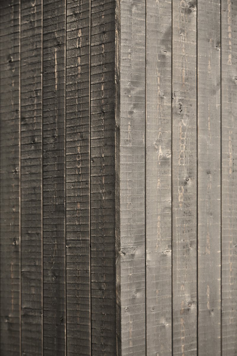 Close-up of charred timber cladding showing vertical grooves and weathered texture