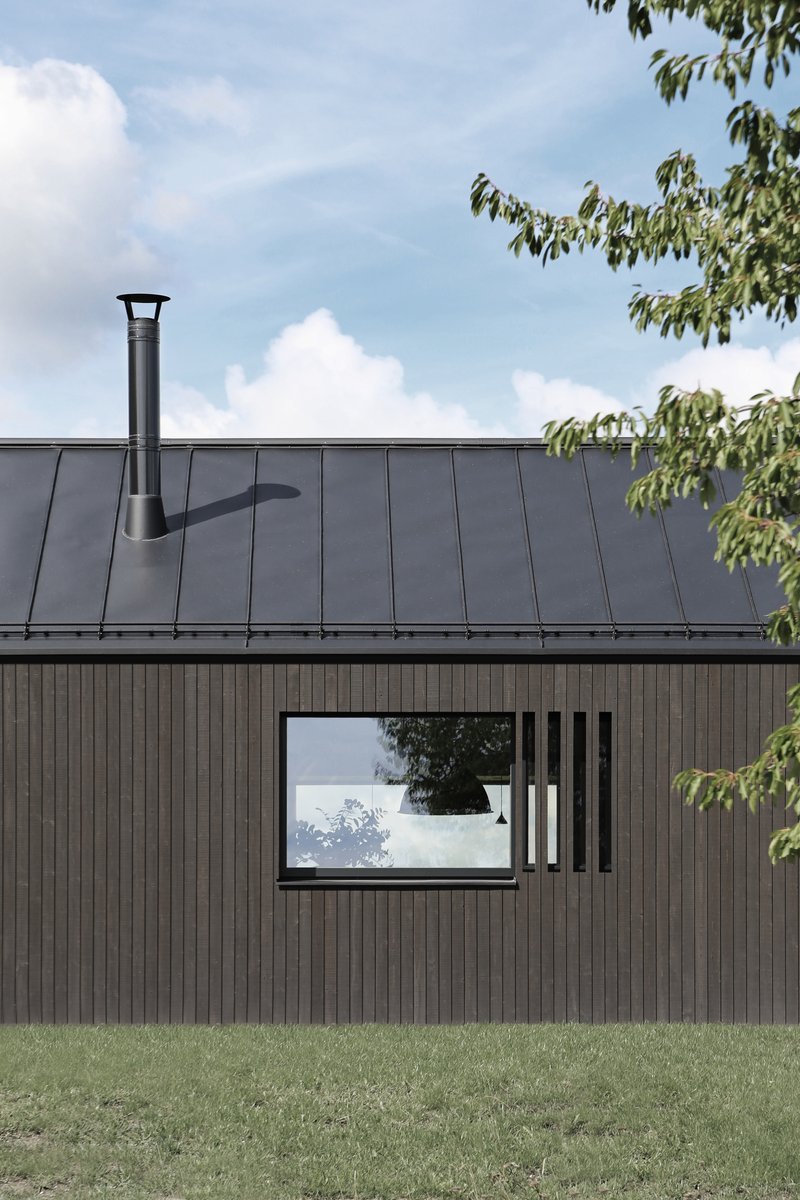 Detail of the timber facade with horizontal window and metal chimney flue on the standing seam roof