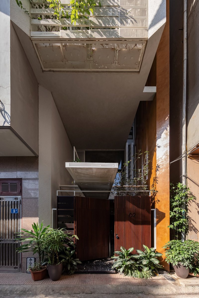 View up through the planted courtyard void showing perforated metal balcony floors and skylight above