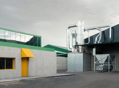 This architectural image showcases a modern industrial building with a minimalist design. The buildi