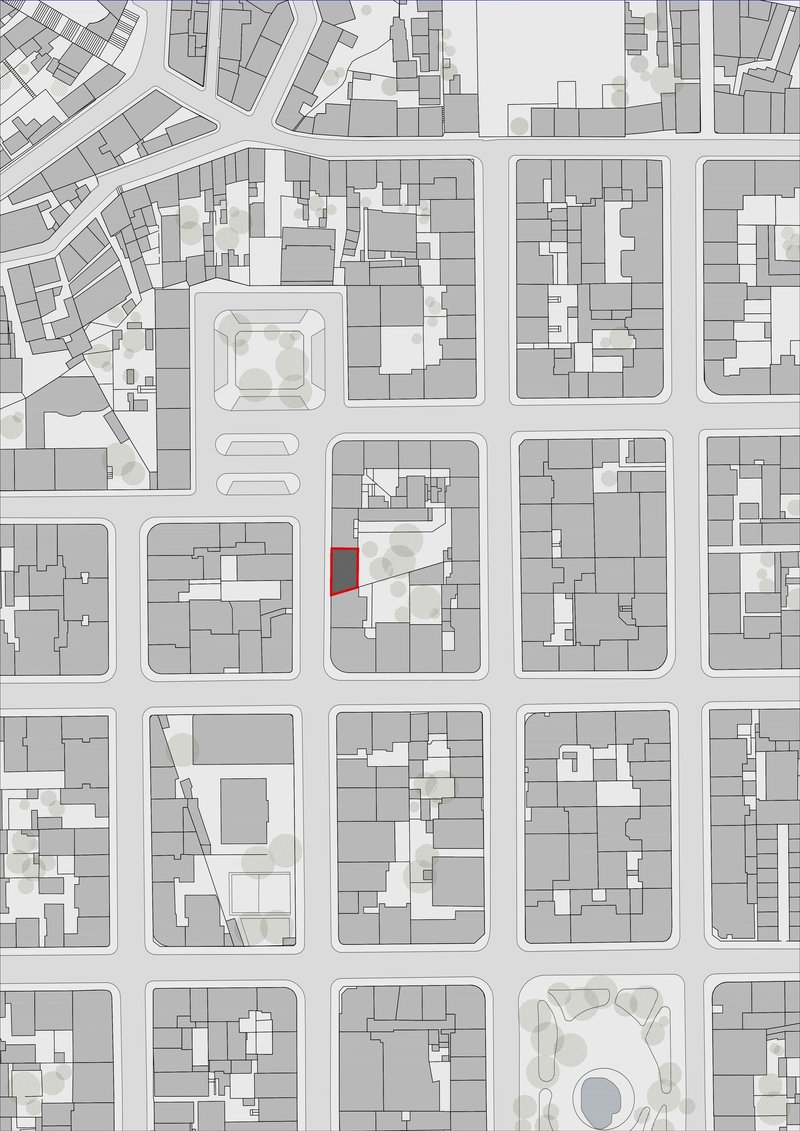 Site plan drawing showing urban blocks with a highlighted corner lot adjacent to a public square