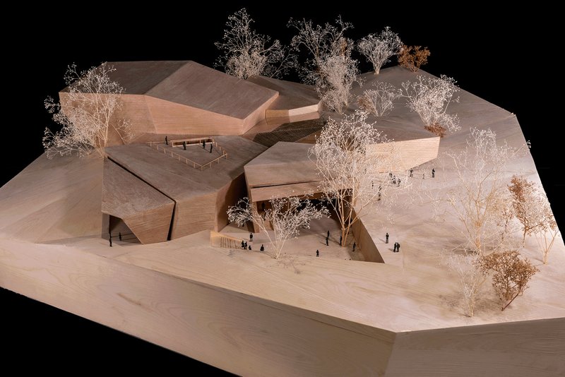 Physical model showing three interlocking volumes with courtyard and white miniature trees throughout