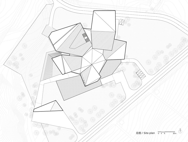 Site plan drawing showing multiple pitched-roof volumes arranged around a central courtyard with trees