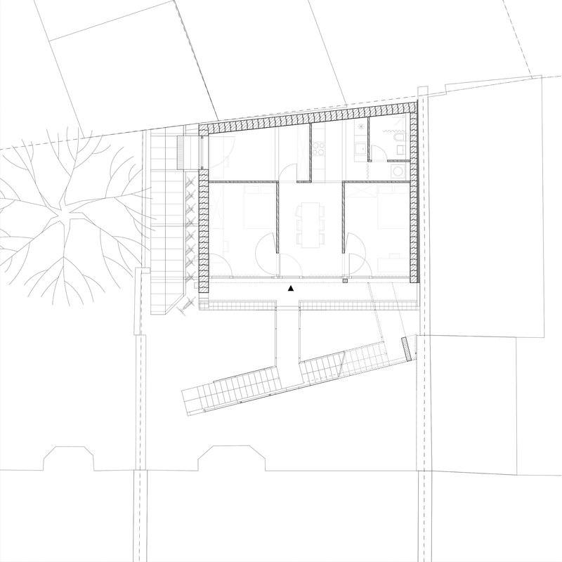 First floor plan drawing showing two interior rooms with a diagonal staircase element and adjacent street trees
