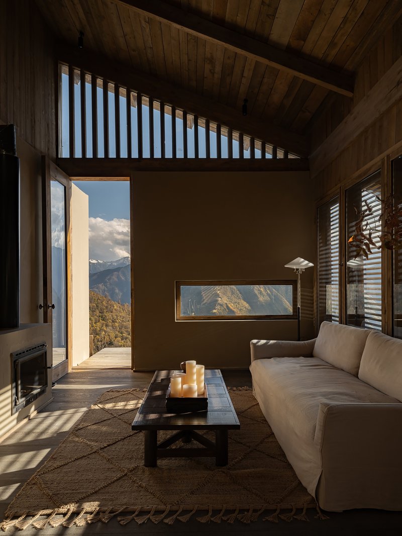 Interior space with timber ceiling and open doorway framing mountain view beyond the terrace