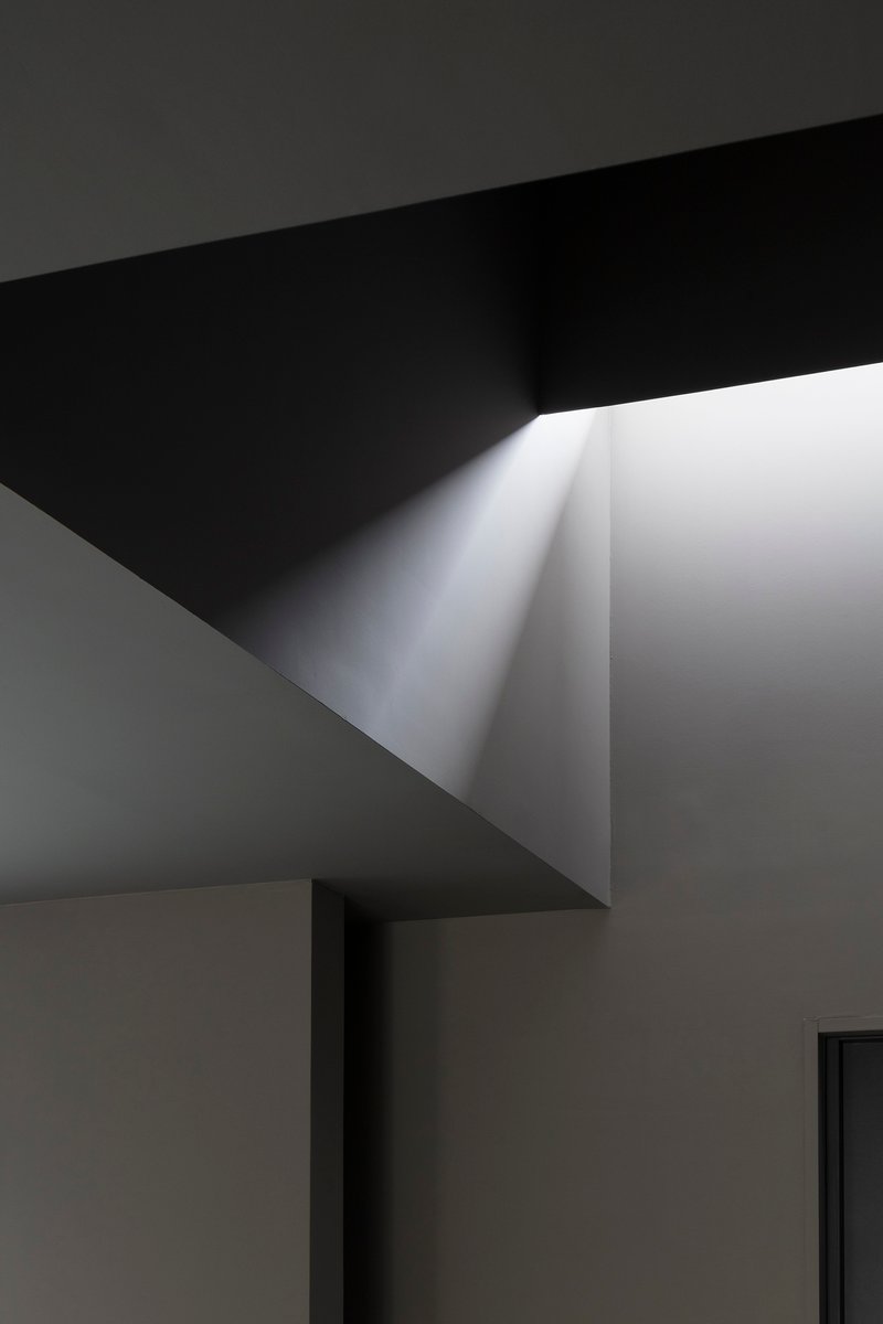 Close-up of angular ceiling geometry with concealed linear light slot at fold
