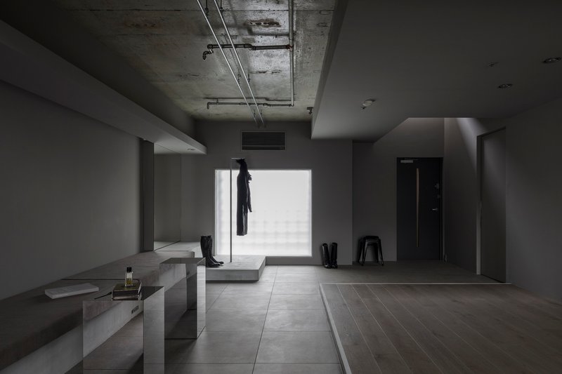 Entry foyer with exposed concrete ceiling, large window opening, and coat hanging on rack