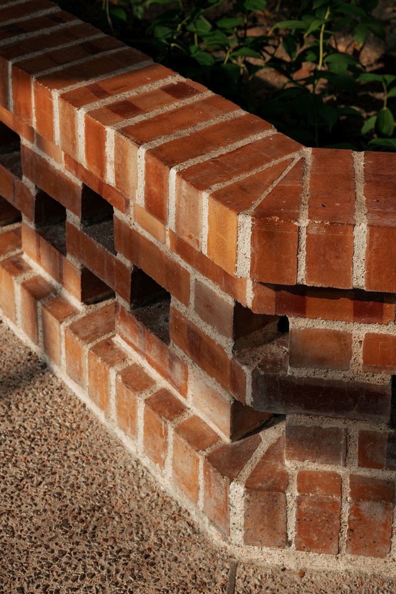 Brick bench detail showing corbelled courses and perforated pattern with gravel base